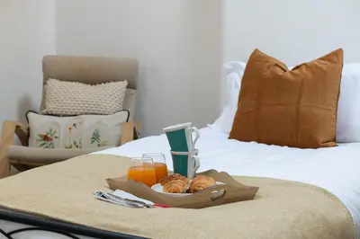 a tray of bread and orange juice on a bed at Brow Top Cottage, Penrith, Lake District in Skelton