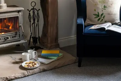 a table with a plate of food and a fireplace at Brow Top Cottage, Penrith, Lake District in Skelton