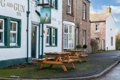 three picnic tables sitting outside of a building at Brow Top Cottage, Penrith, Lake District in Skelton