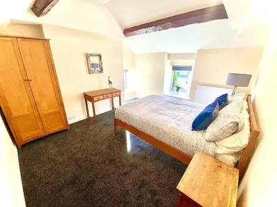 a bedroom with a bed and a wooden cabinet at Mountain Dream Cottage in Ramsey