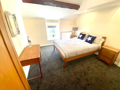 a bedroom with a bed and a table and a window at Mountain Dream Cottage in Ramsey