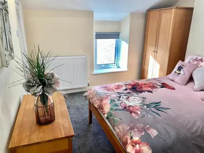 a bedroom with a bed with a vase on a table at Mountain Dream Cottage in Ramsey