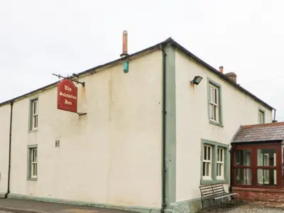 a white building with a sign on the side of it at Rosie's Zen Den in Carlisle
