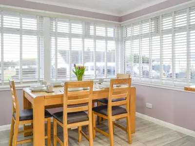 a dining room with a table and chairs and windows at Jura in Mainsriddle
