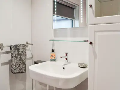 a white bathroom with a sink and a mirror at Jura in Mainsriddle