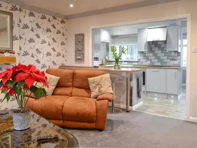 a living room with a couch and a kitchen at Jura in Mainsriddle