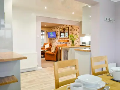 a kitchen and living room with a table and chairs at Jura in Mainsriddle
