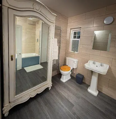 a bathroom with a toilet and a sink and a mirror at Spacious 1st Floor Apartment in Keswick