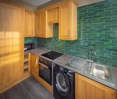 a kitchen with a sink and a washing machine at Spacious 1st Floor Apartment in Keswick
