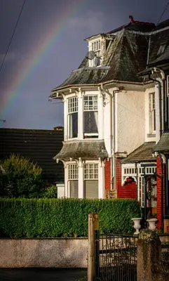 a large white house with a fence in front of it at Spacious Ground Floor Apartment in Keswick