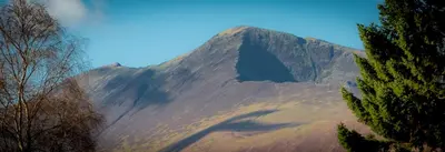 a large mountain in the middle of a field at Spacious Ground Floor Apartment in Keswick