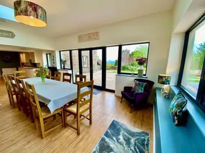 a kitchen and dining room with a table and chairs at Elegant & spacious farmhouse with wonderful views in Penrith
