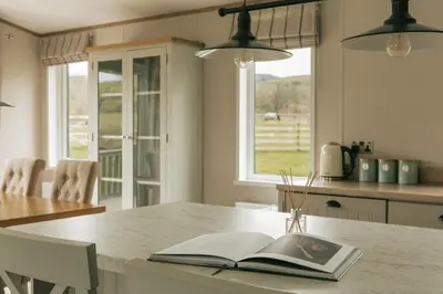 an open book on a table in a kitchen at Snittlegarth Farm Lodges in Wigton