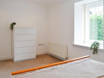 a white bedroom with a bed and a window at Kirroughtree Steading 2 - Uk42904 in Newton Stewart
