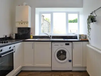 a kitchen with a washing machine and a window at Kirroughtree Steading 2 - Uk42904 in Newton Stewart