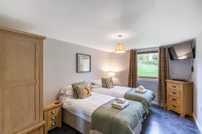 a bedroom with two beds and a tv in it at Lord Galloway 31 with Hot Tub in Newton Stewart