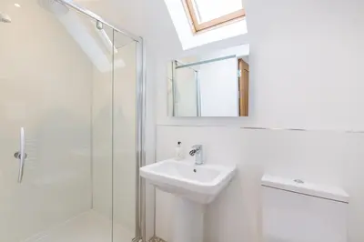 a white bathroom with a sink and a shower at Lord Galloway 31 with Hot Tub in Newton Stewart
