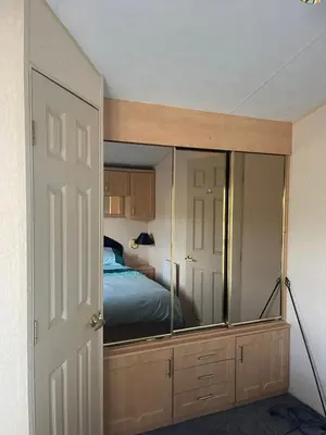 a bedroom with a mirror and a bed at Immaculate 2-Bed Static Caravan at Monrieth in Newton Stewart