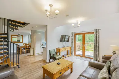 a living room with a couch and a table at Lord Galloway 32 with Hot Tub in Newton Stewart