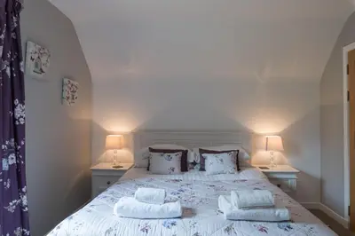 a bedroom with a bed with pillows and two lamps at Lord Galloway 33 with Hot Tub in Newton Stewart