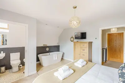 a bedroom with a tub and a toilet and a sink at Lord Galloway 33 with Hot Tub in Newton Stewart
