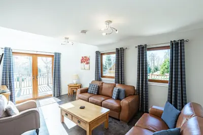 a living room with a couch and a table at Lord Galloway 34 with Hot Tub in Newton Stewart