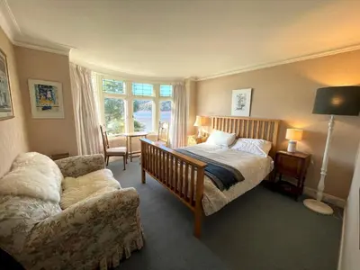 a bedroom with a bed and a couch and a chair at Beautiful 4BR Period Home With Spectacular Views - Pass the Keys in Kippford