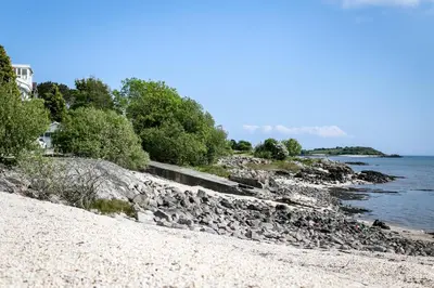 a beach with rocks and trees and the water at Beautiful 4BR Period Home With Spectacular Views - Pass the Keys in Kippford