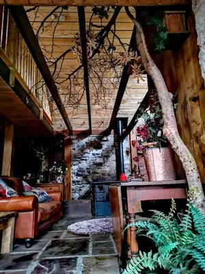 a living room with a couch and a tree at Ranch House in Newton Stewart