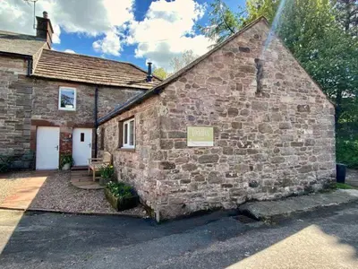 a brick building with a sign on the side of it at Stunning barn minutes from the Lake District in Penrith