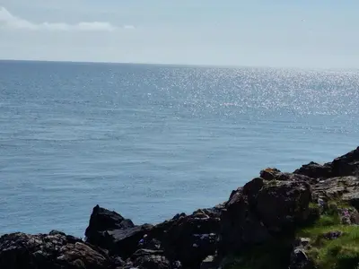 a view of the ocean from a rocky shore at Stunning Caravan Whithorn3 in Newton Stewart