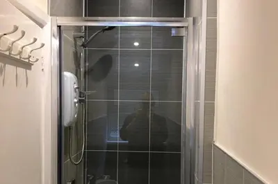 a person taking a picture of a shower in a bathroom at Cottage - Sleeps 4 - Pets Ok - Garden - Parking in Keswick