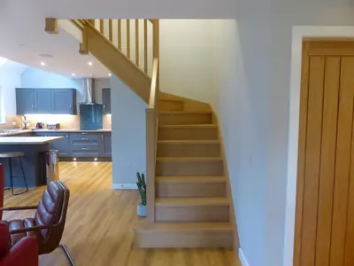 a staircase leading to a kitchen and a living room at Lord Galloway 37 with Hot Tub in Newton Stewart