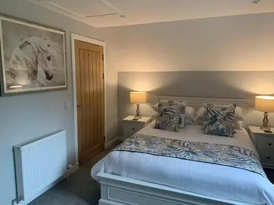 a bedroom with a large bed with two lamps at Lord Galloway 37 with Hot Tub in Newton Stewart