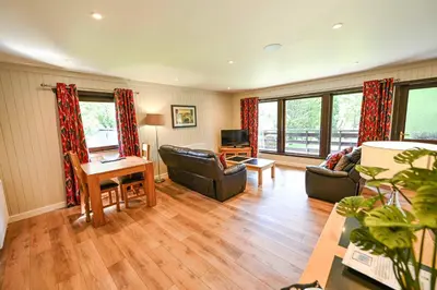 a living room with a couch and a table at Bluebell Lodge 2 with Hot Tub in Newton Stewart