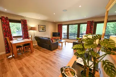 a living room with a couch and a table at Bluebell Lodge 2 with Hot Tub in Newton Stewart