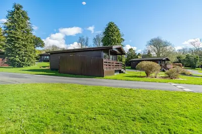 a house on the side of a road at Birch Lodge 12 with Hot Tub in Newton Stewart