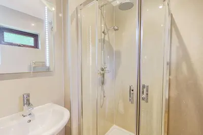 a bathroom with a shower and a sink at Bluebell Lodge 4 with Hot Tub in Newton Stewart