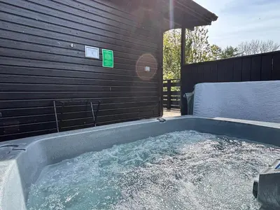 a jacuzzi tub with water in a backyard at Bluebell Lodge 5 with Hot Tub in Newton Stewart