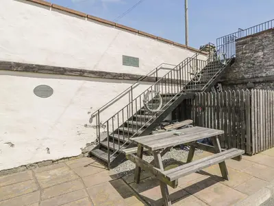 a picnic table and stairs on a building with a bench at Tides Reach in Newton Stewart