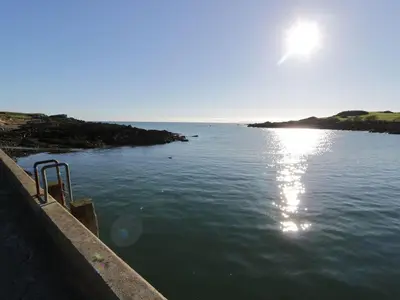 a body of water with the sun in the sky at Tides Reach in Newton Stewart