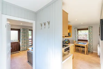 a kitchen and a living room with a table at Bluebell Lodge 7 with Hot Tub in Newton Stewart