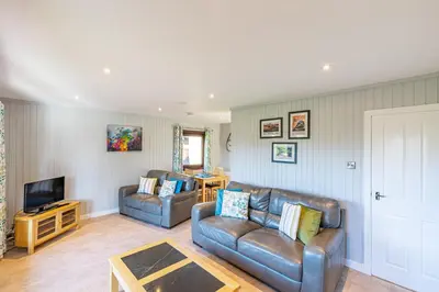 a living room with two couches and a television at Bluebell Lodge 7 with Hot Tub in Newton Stewart
