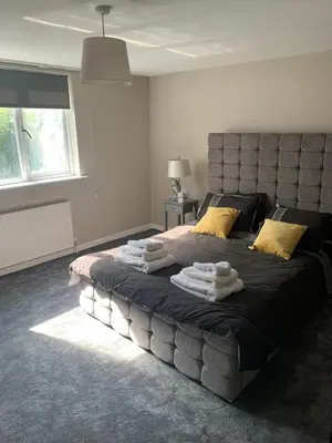 a bedroom with a large bed with towels on it at Elegant bungalow in Newmilns, East Ayrshire in Newmilns