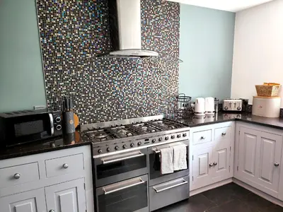 a kitchen with a stove and a microwave at Sanderson House in Cleator Moor