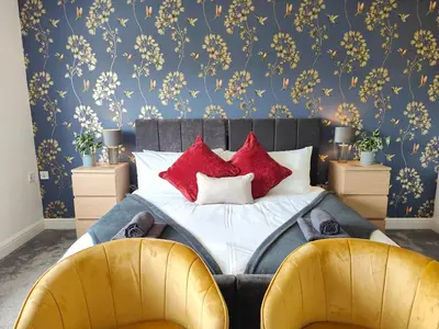 a bedroom with a bed with red pillows on it at Sanderson House in Cleator Moor