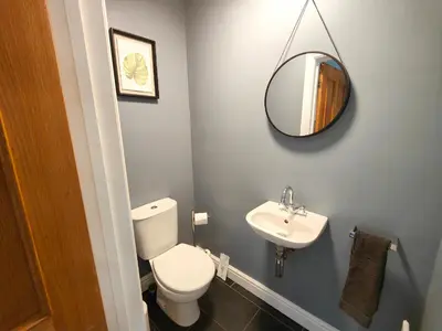 a bathroom with a toilet and a sink and a mirror at Sanderson House in Cleator Moor