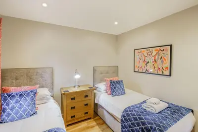 a bedroom with two beds and a dresser at Birch Lodge 13 with Hot Tub in Newton Stewart