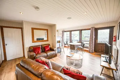 a living room with a couch and a table at Birch Lodge 14 with Hot Tub in Newton Stewart