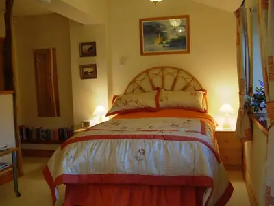a bedroom with a large bed with two lamps at Damson Ghyll B&B in Loweswater